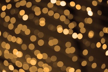 abstract defocused golden round bokeh or warm white bubble from orange light party on black at night for yellow background and christmas day celebrate or happy new year festival