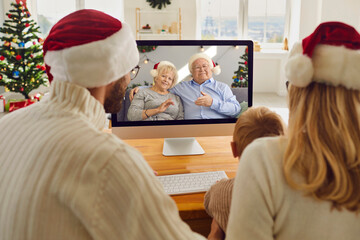 Young family staying at home on Christmas holidays but keeping in touch with grandparents