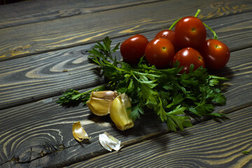 tomatoes, parsley and garlic are on an old table