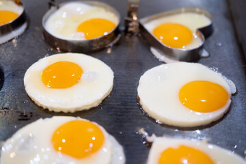 Cooking fried egg on stove stainless steel for customer come to stay at hotel