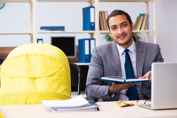 Young male employee looking after newborn at workplace