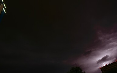 dark night sky over the city with the corners of buildings at the edges in the evening illumination