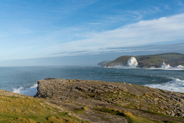 huge storm surge ocean waves crashing onto shore and cliffs