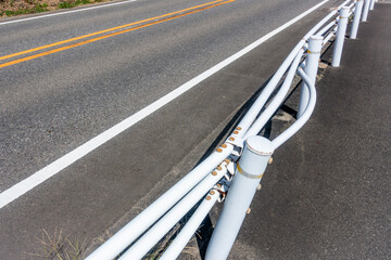 車が衝突して変形したガードレールの写真