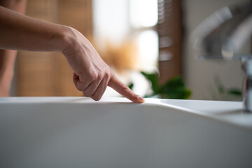 Professional cleaning of the bathroom and toilet. Cleanliness and hygiene at home. Cleaning service and housekeeping. checking cleanliness with a finger. Clean surface. Rubbing the bathroom and taps