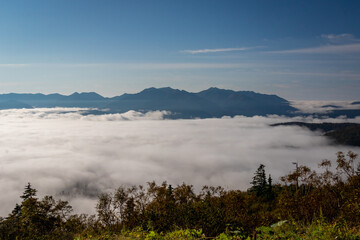 北海道・大雪山系の赤岳にある、銀泉台の登山口で見た、山々の間に雲海が広がる神秘的な風景と青空