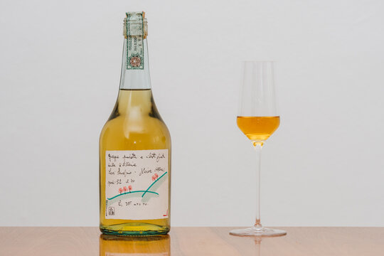 Neive, Alba, Italy - January 11 2020: Original Romano Levi Grappa Bottle with Drawing from 1995 with a spirits glass.