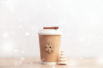 paper cup of coffee on a white and wooden christmas background.