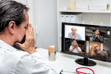 Fototapeta na wymiar exhausted male doctor is having a conference with four patients, having covid symptoms