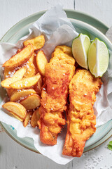 Tasty fish and chips served with sauces and lime