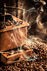 Old grinder and fresh roasted coffee beans with smoke