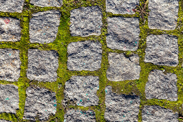 Fragment of the road paved with an old granite stone (can be used as a background)