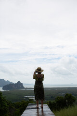 A woman with a hat standing to admire the view