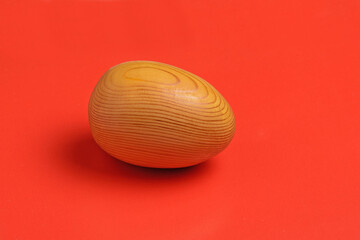 Wooden egg on a red background close-up