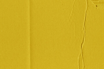 Fototapeta premium A yellow vintage rough sheet of carton. Recycled environmentally friendly cardboard paper texture. Simple and bright minimalist papercraft background.