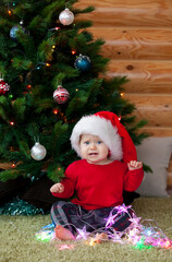 Cute baby Santa near New Year tree