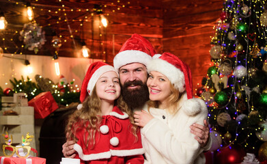 By golly, be jolly. merry christmas. Father and mother love daughter. Happy family celebrate new year. lot of xmas present boxes. small child and parents in santa hat. Portrait loving family