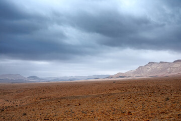 Rocky deserted landscape under a stormy sky.