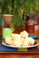Breakfast, with starch biscuit, cheese bread, served on a wooden table outdoors. Farm breakfast. Coffee, coffee strainer on the table.