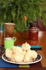 Breakfast, with starch biscuit, cheese bread, served on a wooden table outdoors. Farm breakfast. Coffee, coffee strainer on the table.