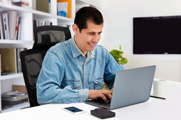 Shot of a handsome young businessman sitting behind his laptop in his office