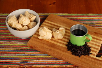 Breakfast, with starch biscuit, cheese bread, served on a wooden table outdoors. Farm breakfast. Coffee, coffee strainer on the table.