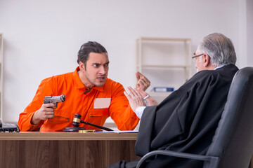 Old male judge meeting with young captive in courthouse