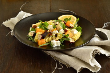 Pasta with baked pumpkin, feta, herbs and hazelnuts,  copy space