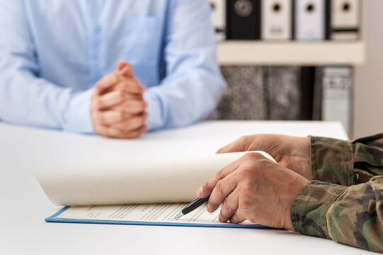 Cropped shot of a man and military man completing paperwork together at a desk