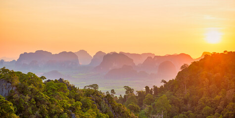 Beautiful tropical landscape with mountain rainforest and steep rocky ridge at horizon at sunset. Krabi, Thailand