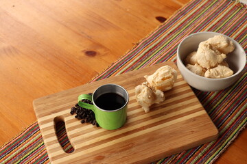 Breakfast, with starch biscuit, cheese bread, served on a wooden table outdoors. Farm breakfast. Coffee, coffee strainer on the table.