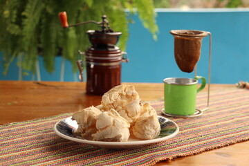 Breakfast, with starch biscuit, cheese bread, served on a wooden table outdoors. Farm breakfast. Coffee, coffee strainer on the table.