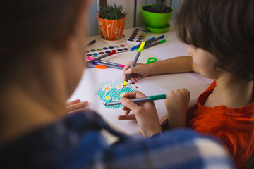 child with a teacher is engaged in art therapy