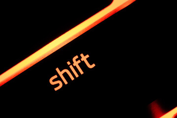 Green illuminated keyboard shift key closeup