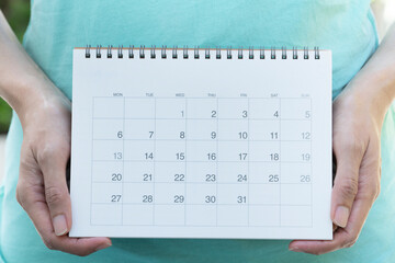 close up of woman hand holding calendar for planner, business, check for period schedule, healthy...
