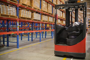 A red forklift is parked in the warehouse.Moving products in the factory © pongsakorn