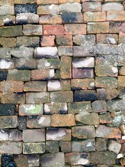 
stones road brick old brick burnt in moss green chipped crumbling paving construction road masonry clay earth village