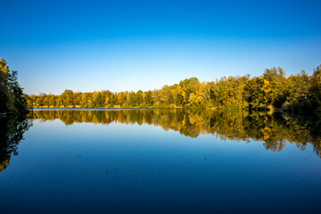 A beautiful little lake called Schnepfensee in Germany at a sunny day in Autumn with a colorful...