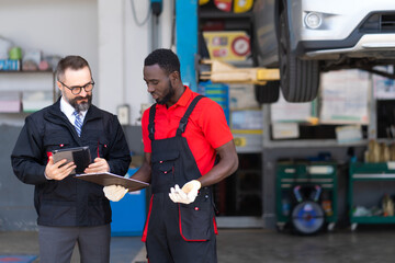 Car insurance and non life insurance concept. Insurance assessor and mechanic car repair man examine to the car damage.