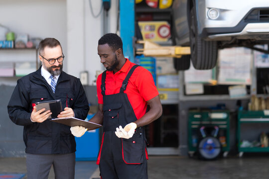 Car insurance and non life insurance concept. Insurance assessor and mechanic car repair man examine to the car damage.