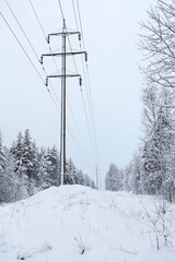 Power supply high voltage line is in snowy winter forest, nobody