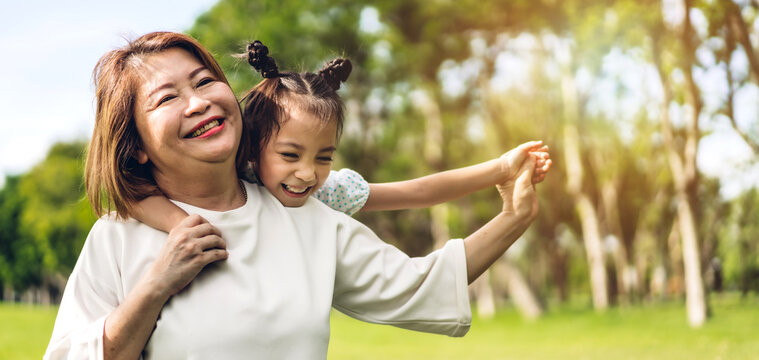 Portrait of happy asian grandmother and little cute girl enjoy relax together in summer park.Family and togetherness