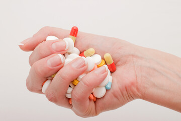 Female hand holds pills on a white background. Concept of treatment of recovery and prevention
