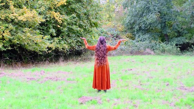 beautiful woman with long curly hair, rapunzel in a medieval vintage dress stands in the autumn in the park in the rain, the concept of a healthy lifestyle, good mood