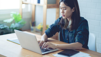 Asian women working at home using a lab. Graphic design. Working with pleasure. Concept work at home.