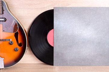 Vintage vinyl discs and country mandolin on wooden background