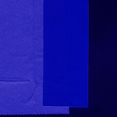 Fototapeta premium Blue and violet torn paper collage close-up. Texture made from various paper and cardboard parts. Damaged old paper background. Vintage blank wallpaper. Material design backdrop.