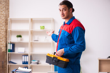 Young male contractor repairing furniture in the office