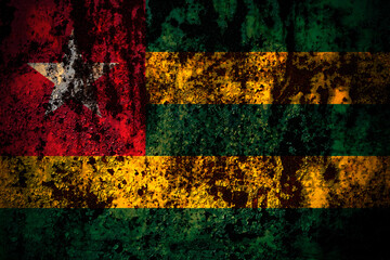 Togo flag on grunge metal background texture with scratches and cracks