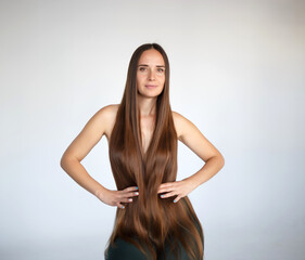 young beautiful woman with very long hair sits on a chair